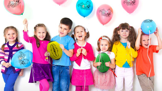 Group of smiling children holding party balloons and rugby balls for kids rugby party